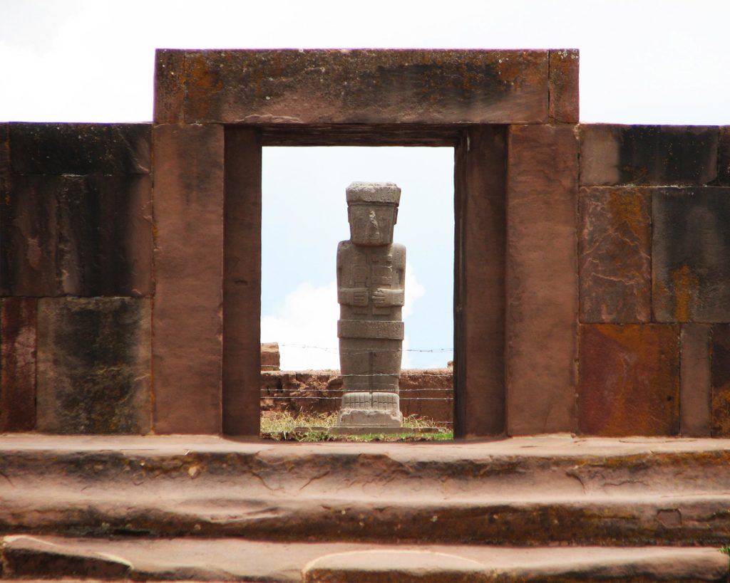 Bolivia, Tiwanaku arkeologiske komplekset. Den megalitiske porten til tempelet med en monolittfigur i bakgrunnen. 