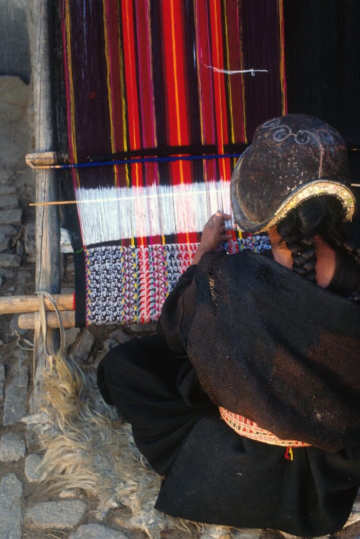 Bolivia. Dame i klær fra Chuquisaca vever tradisjonelt mønster. Foto