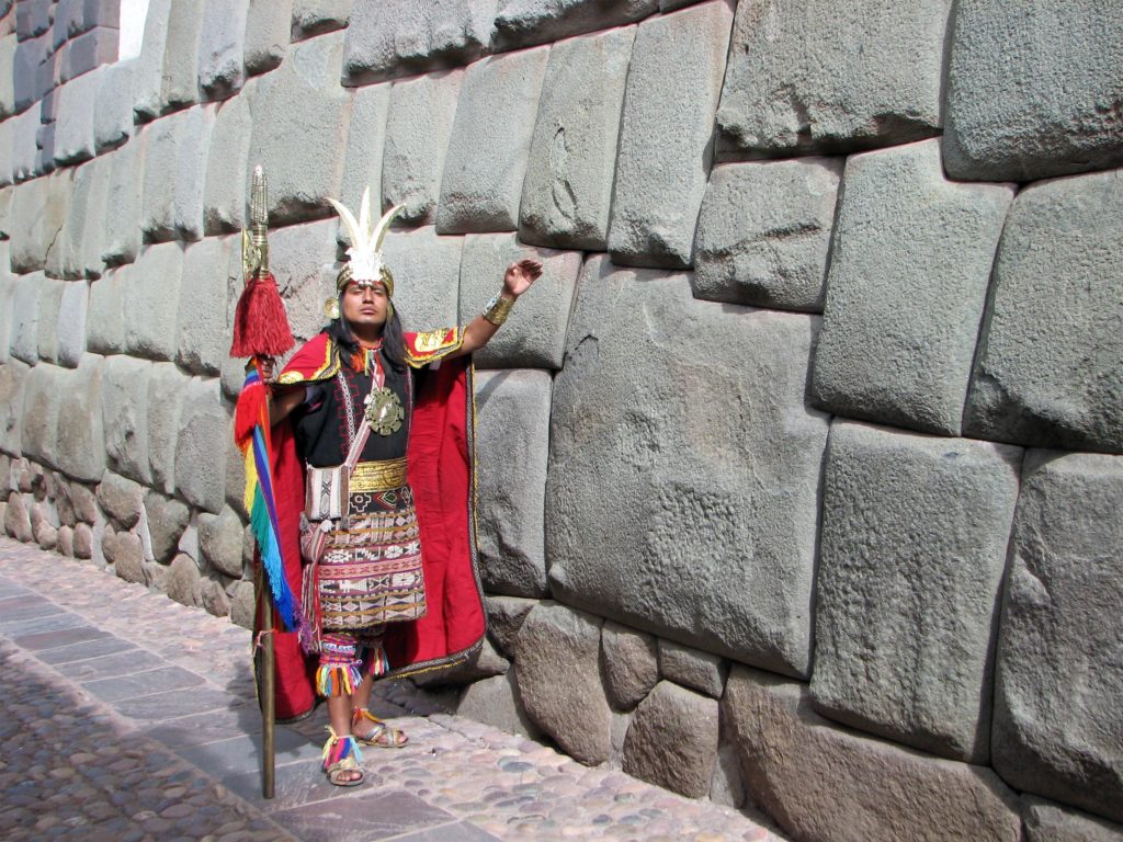 Peru. Cusco. Mann i inka-klær ved inkaenes 12-hjørners stein. Foto