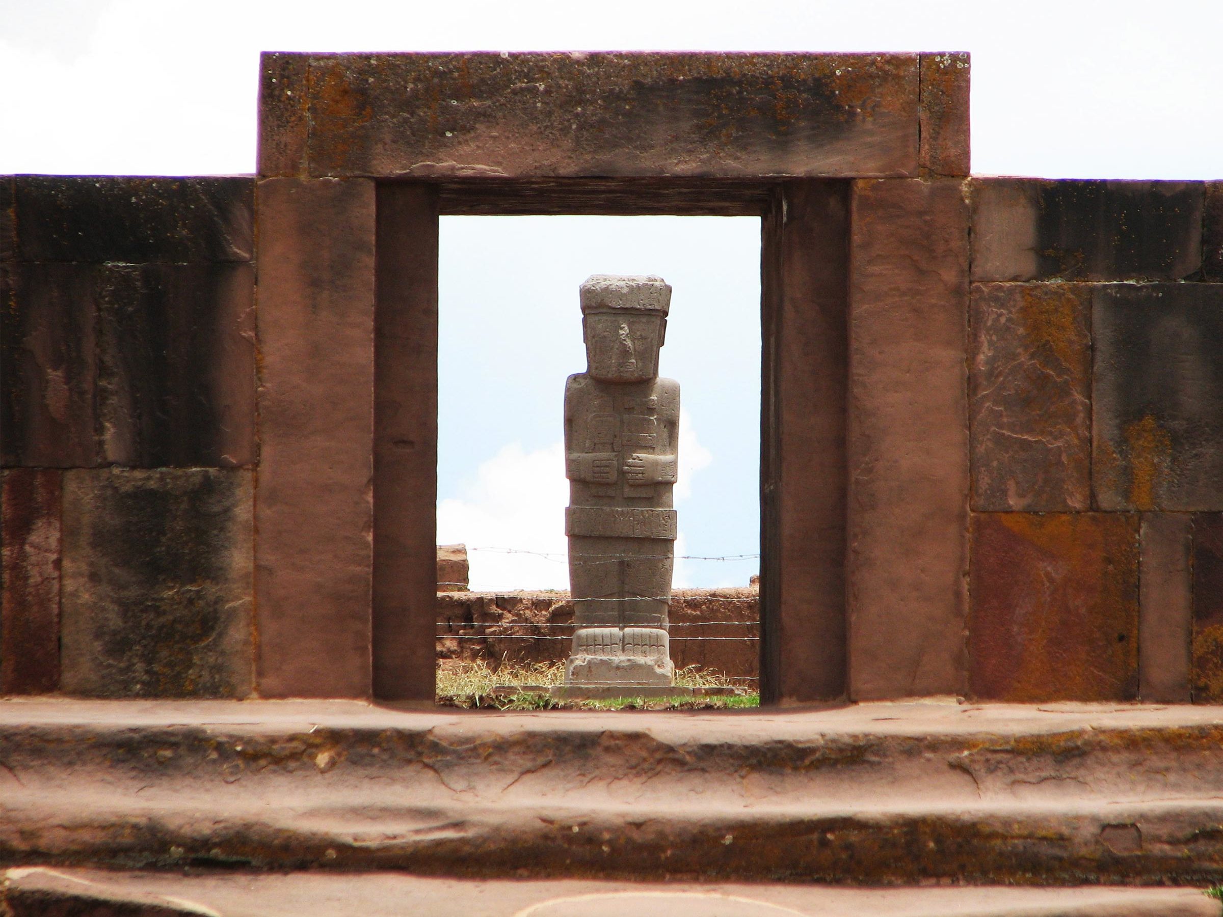 Bolivia, Tiwanaku arkeologiske komplekset. Den megalitiske porten til tempelet med en monolittfigur i bakgrunnen.