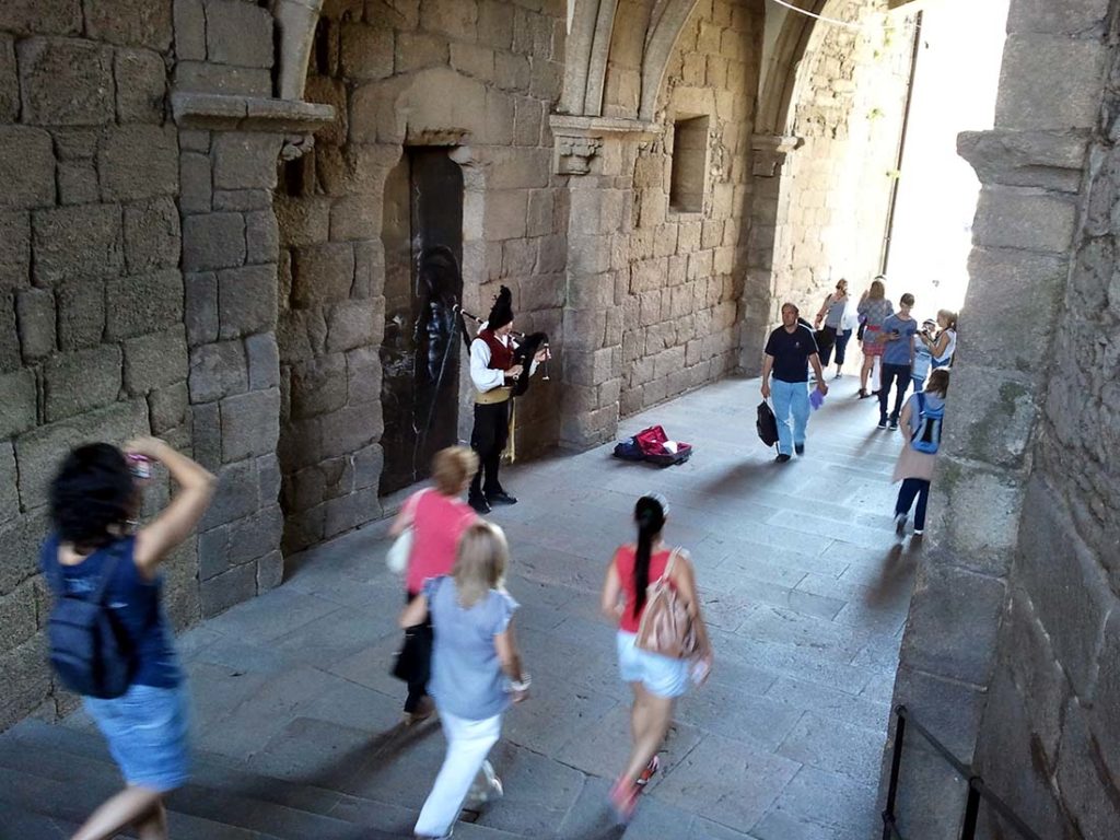 Spania. Santiago de Compostela. Gatemusiker i tradisjonell drakt spiller sekkepipa. Foto 