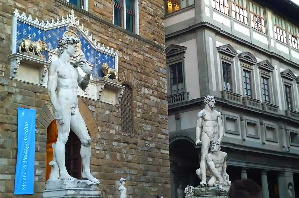 Italia. Firenze. Skulpturer av Michelangelos David (kopi) og Bandinellis Hercules og Cacus foran Palazzo Vecchio på Piazza della Signoria. Foto