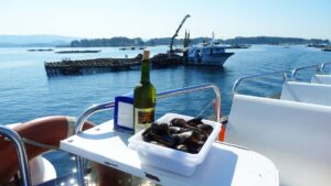 Spania. Galicia. Hvitvin og blåskjell serveres på båten i Galiciske fjord. Foto