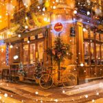 Paris. En gatehjørne med parkert sykkel og julepynt i juletid.