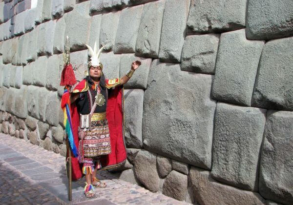 Peru. Cusco. Mann i inka-klær ved inkaenes 12-hjørners stein. Foto